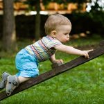  happy young boy creeping on the ladder in the park