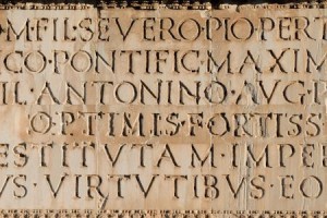 Close up of ancient Roman Latin Inscription in stone background.