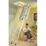 extended loft ladder with lady sat in a chair below beside a picture and house plant